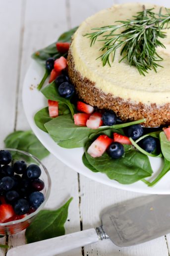 Top shot of a blue cheese cheesecake on a serving plate dressed with fruit