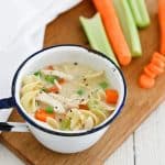 Creamy chicken noodle soup in a bowl on a wooden work surface