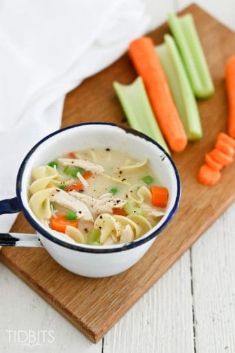 Creamy chicken noodle soup in a bowl on a wooden work surface