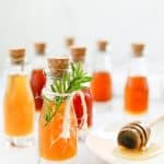 Bottles of infused honey on a white background