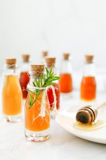 Bottles of infused honey on a white background