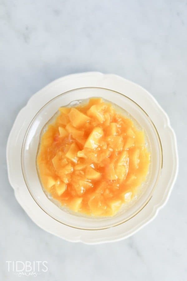 A plate of peach compote on a marble surface