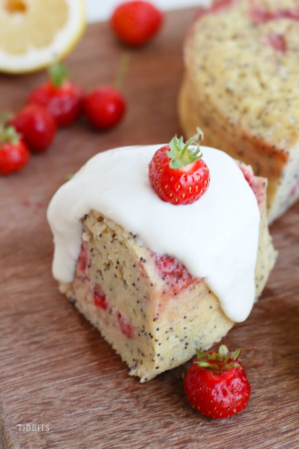 Close up of a slice of breakfast cake next to fresh strawberries
