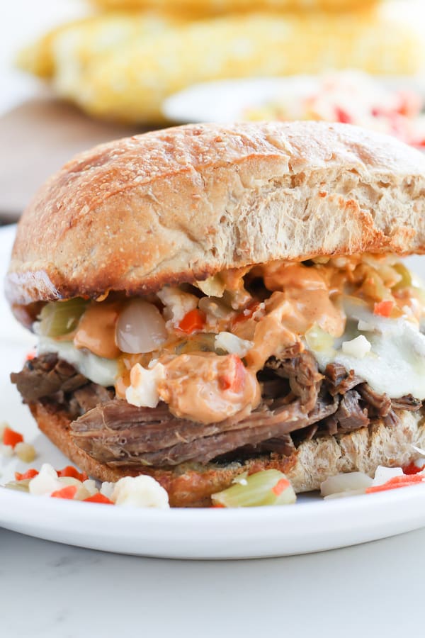 Close up of a Pressure Cooker Pepperoncini Beef sandwich on a white plate