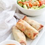 Pepperoncini Beef Egg Rolls on a white serving plate with dip