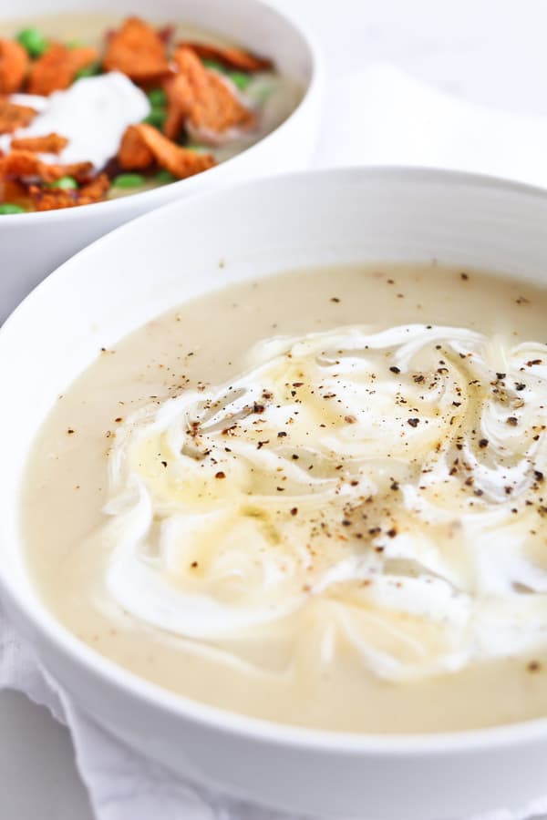 A bowl of Pressure cooker baked potato soup on a white cloth