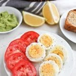 Pressure cooker boiled eggs and fresh tomatoes sliced on a plate