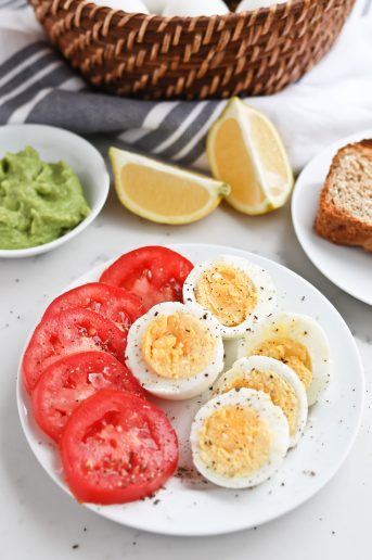 Pressure cooker boiled eggs and fresh tomatoes sliced on a plate