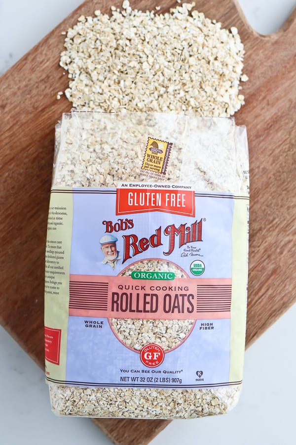 Rolled oats in packaging on a wooden chopping board