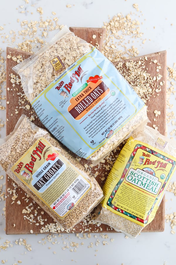 Three packages of oats on a wooden board