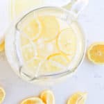 Instant Pot Lemonade in a pitcher with ice and lemon slices