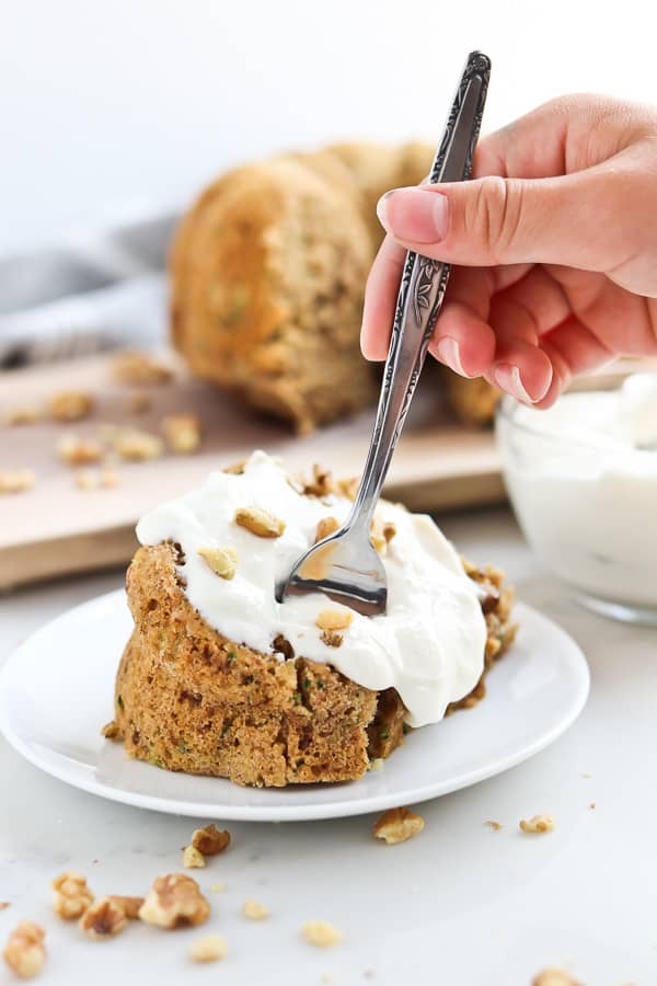 zucchini bread with yogurt sauce on a plate with a fork