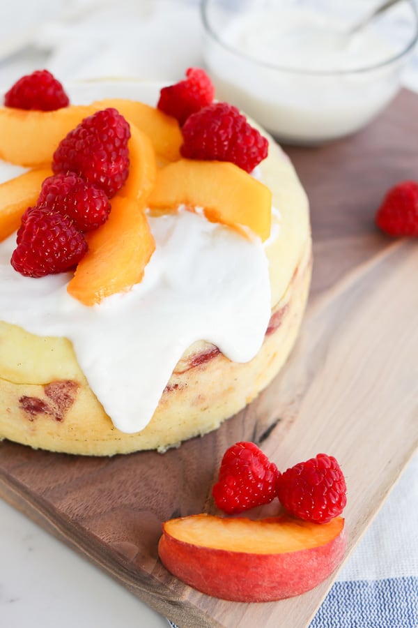 Raspberry Peach Breakfast Cake with yogurt sauce on a cutting board
