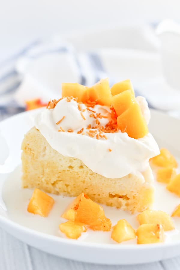 tres leches cake with peaches and cream in a bowl