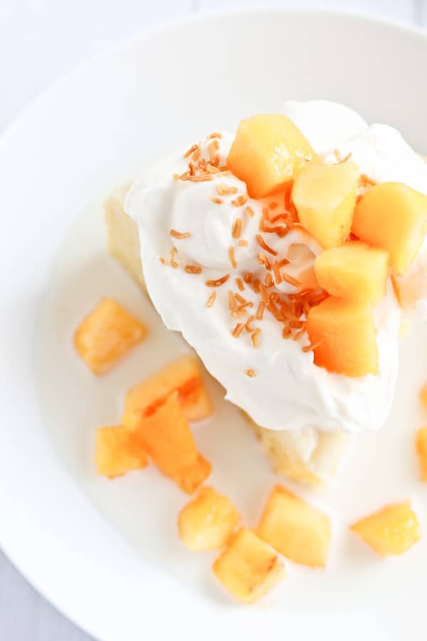 tres leches cake with peaches and cream in a bowl