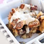 Apple Cinnamon French Toast Casserole in a white bowl with cream sauce