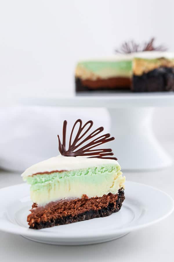 Mint cheesecake on a white plate with chocolate garnish