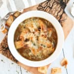 french onion soup in a white bowl with cheese melted on top