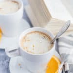 Chocolate drink in a white cup with cream and orange slices