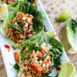 Instant Pot Asian Chicken Lettuce Wraps on a white plate with limes