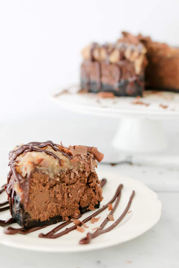 Instant Pot German Chocolate Cheesecake on a white plate with chocolate drizzle
