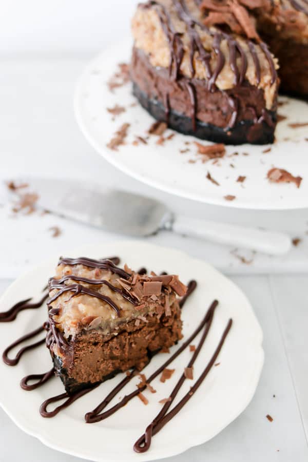 Instant Pot German Chocolate Cheesecake on a white plate with chocolate drizzle