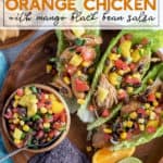 Instant Pot Orange Chicken with Mango Black Bean Salsa in lettuce wraps on a wood plate