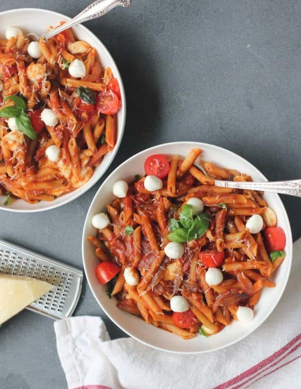 Bowl of pasta with tomatoes, basil, and mozzarella