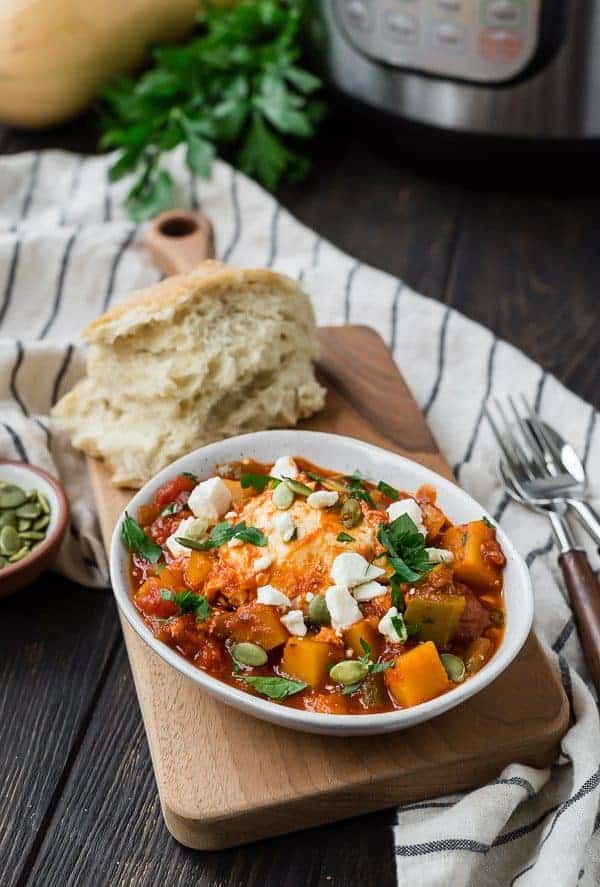 Butternut squash shakshuka in a white bowl with bread
