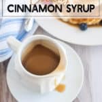 Cinnamon Syrup in a white cup on a white plate with pancakes in the background