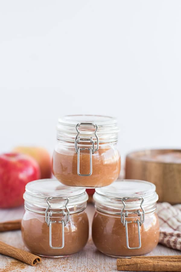 applesauce in clear jars with apples in background