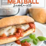 meatball sandwich on a white plate with basil