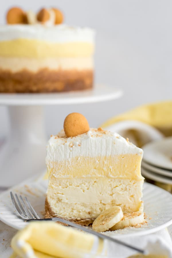 slice of Banana cream pie cheesecake on a white plate with yellow napkins