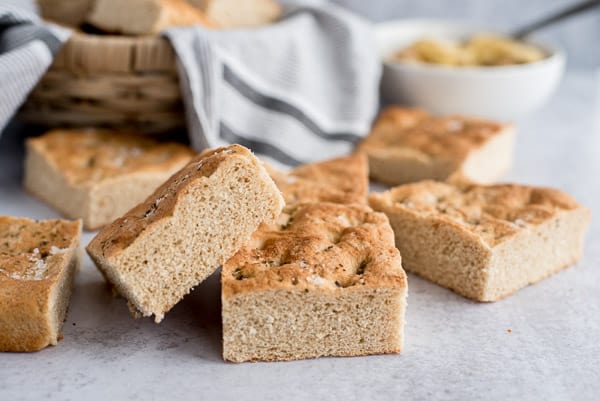 whole wheat focaccia bread stacked by a basket