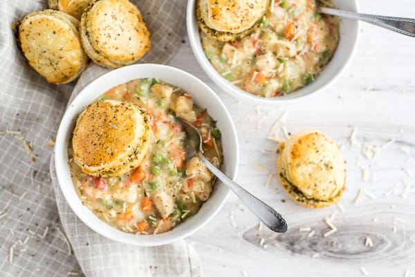 Bowl of chicken pot pie with a biscuit on top and a spoon