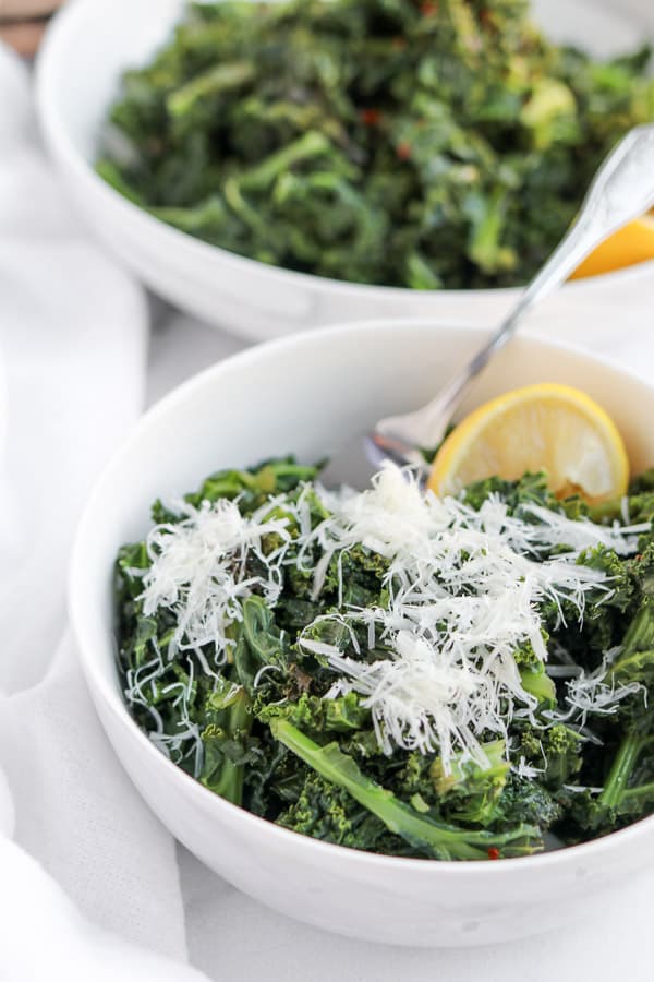 kale with lemon and parmesan in a white bowl
