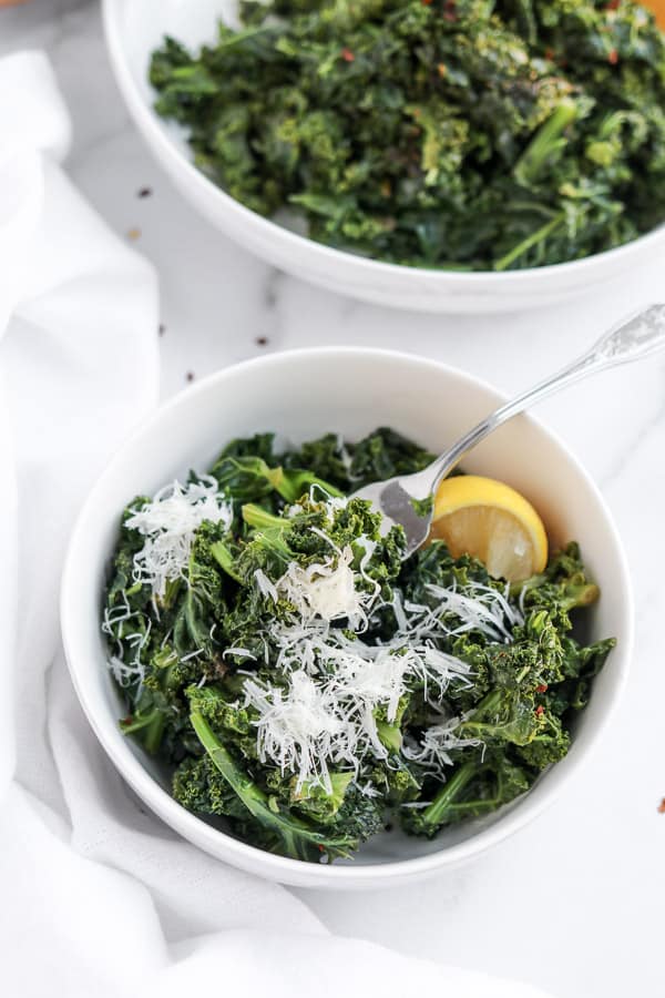 kale with lemon and parmesan in a white bowl