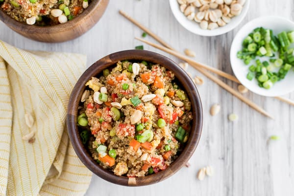 brown bowl with quinoa, peas, corn, and edamame with chopsticks