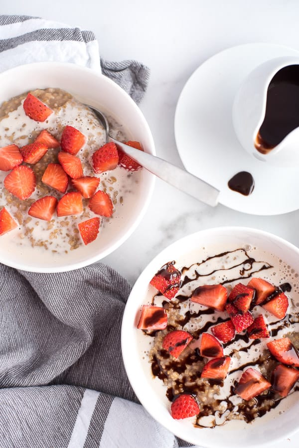 2 bowls of oatmeal, one with strawberries and chocolate and one with just strawberries