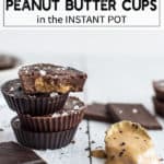 Chocolate peanut butter cups stacked on top of each other on a white surface with a scoop of peanut butter