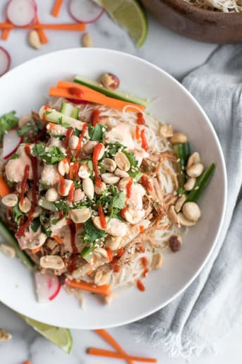 Instant Pot Bahn Mi in a white bowl with carrots, cilantro, and radishes