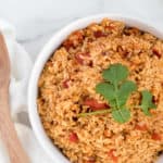 mexican rice with tomatoes in a white dish