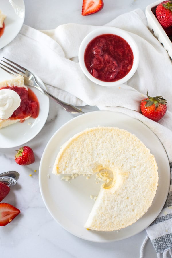 Angel food cake cut into slices and topped with strawberry sauce