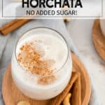 Glass of horchata with ice and cinnamon on a wood plate