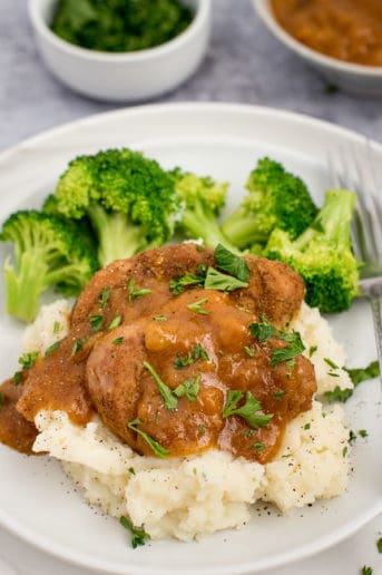Pork chops and apricot sauce on a bed of mashed potatoes with broccoli