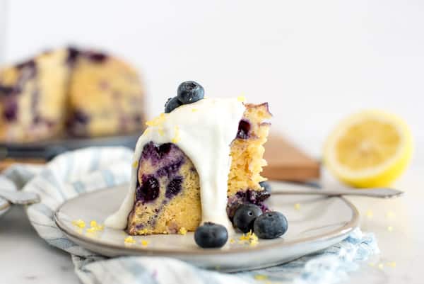 blueberry breakfast cake on a white plate with yogurt sauce
