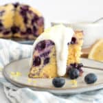 blueberry breakfast cake on a white plate with yogurt sauce