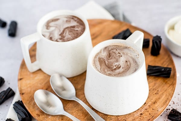 chocolate drink in a white cup with a spoon and cream