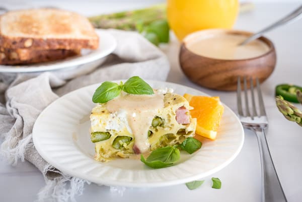 Instant Pot Spring Frittata in a white dish topped with herbs and an orange slice