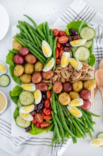 Nicoise salad with green beans, tomatoes, potatoes, cucumbers, tuna, and hardboiled eggs